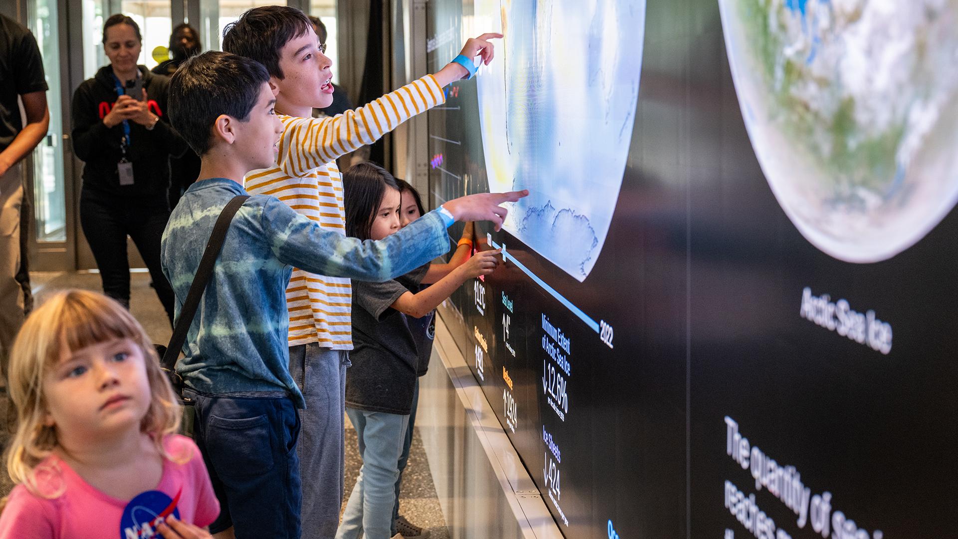 Families interacting with The Earth Information Center's Hyperwall at NASA Headquarters.